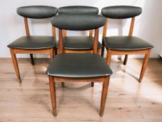 A set of four 20th century teak and black vinyl upholstered dining chairs.