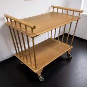 A 20th century teak and plywood two tier serving trolley on castors, length 67 cm.