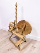 A contemporary pine and beech spinning wheel, height 86 cm.