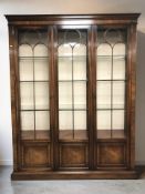 A reproduction mahogany triple door display cabinet,