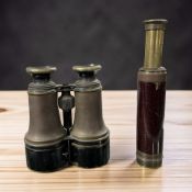 A pair of antique lacquered brass binoculars and a telescope.