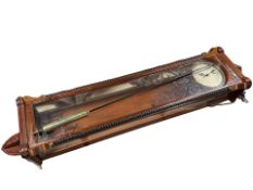 A reproduction mahogany and ebonised electric wall timepiece, with pendulum, height 150 cm.