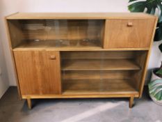 A 20th century teak sliding glass door bookcase, 123 cm x 29 cm x 96 cm.
