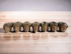 A plaster seven sconce handle holder in the form of a row of hooded figures, width 50 cm.