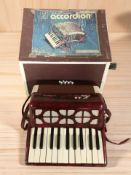 A vintage child's accordion, in box measuring 35 cm wide.