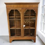 A reproduction mahogany double door bookcase, 77 cm x 25 cm x 107 cm.