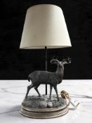 A contemporary resin table lamp surmounted by a stag, height 59 cm.