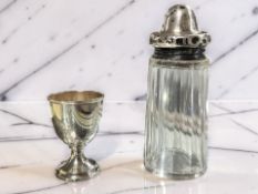 A silver egg cup, height 6.5 cm, and a silver topped crystal sifter.