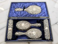 An Edward VII silver-backed six-piece dressing table set, Chester 1906, longest piece 25cm, cased.