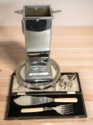 A cased set of EPNS fish servers, plated circular stand with mirrored top,