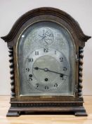 An early 20th century oak barley twist tempus fugit mantel clock with silvered dial,