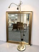 A gilt and bevelled over mantel mirror, 117 cm x 91 cm, together with a brass standard lamp.
