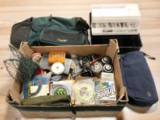 A group of fishing equipment including reels, spools of line, plastic concertina storage box, etc.