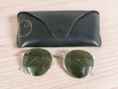 A pair of Ray Ban sunglasses in leather pouch.