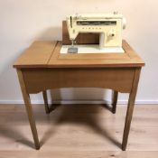 A Singer electric sewing machine in teak table.