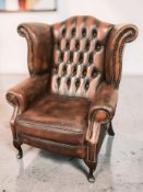 A contemporary Chesterfield wingback oxblood buttoned leather armchair, width 104 cm.