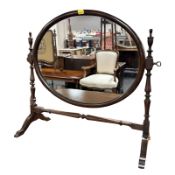 An early 20th century mahogany oval swing mirror, width 58 cm.