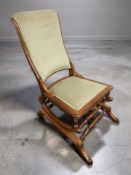 A reproduction rocking chair in green draylon upholstery.