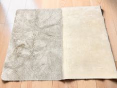 Two contemporary machine made cream rugs, the larger 150 cm x 100 cm.