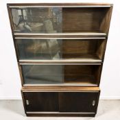 A reproduction mahogany sliding glass door bookcase, 91 cm x 26 cm x 134 cm.