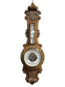 A carved oak aneroid barometer, retailed by Walker & Son, Sunderland, height 63 cm.