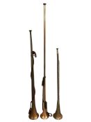 Three copper and brass hunting horns, longest 104 cm.