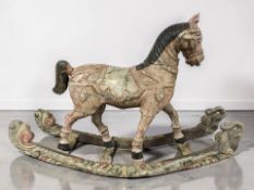 A carved and polychrome painted rocking horse, length 90 cm.