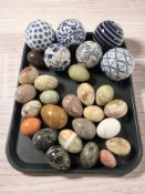 A group of blue and white ceramic carpet bowls, polished onyx and hardstone eggs.