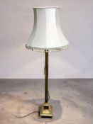 A brass corinthian column standard lamp, with tasselled shade.