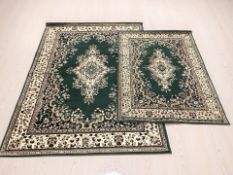 Two machine made Persian-style rugs on green ground, the largest 232 cm x 165 cm.