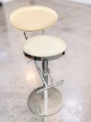 A tan vinyl upholstered swivel bar stool.