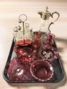 A group of Victorian cranberry glass items, claret jug, pewter sherry label and an EPNS cruet.