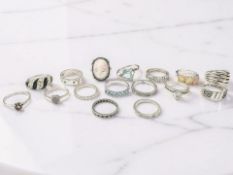 Sixteen dress rings, including a pink cameo example, another with opalescent stones, etc,