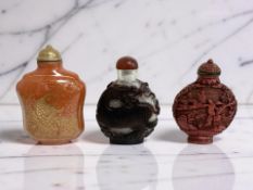 Three Chinese snuff or scent bottles, one carved cinnabar, one carved with a bird and dragon,