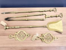 A brass three-piece fire companion set comprising the poker, tongs and shovel,