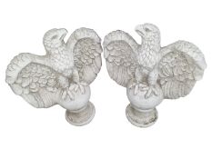 A pair of concrete eagle figures on plinths, height 67 cm.