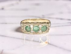 A 9ct yellow gold synthetic emerald three stone ring, size O CONDITION REPORT: 2.