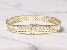 A 9ct three-tone gold bracelet, length 18 cm, width 7 mm CONDITION REPORT: 15.
