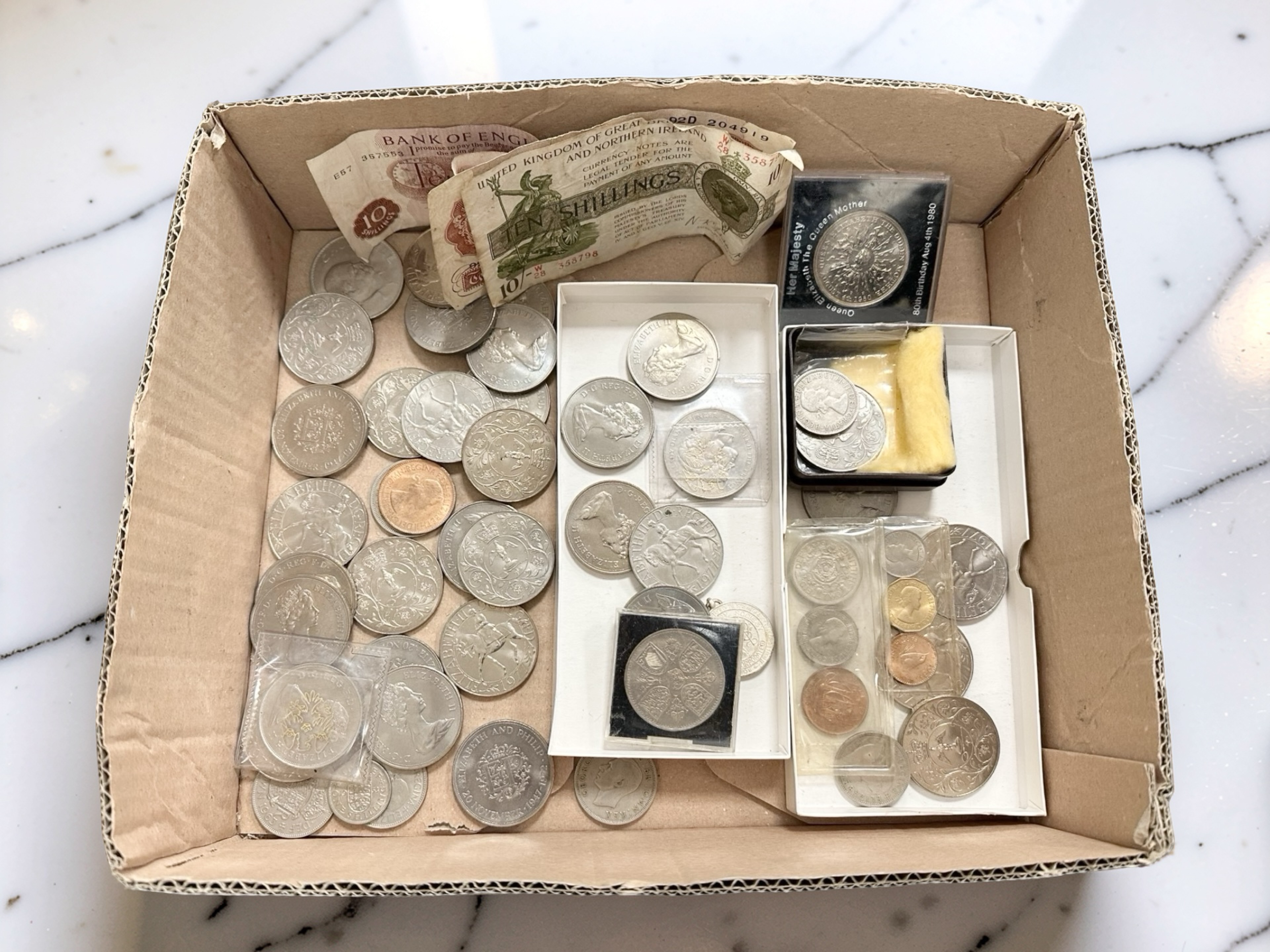 A small box of mixed British crowns, 10 shilling bank notes,
