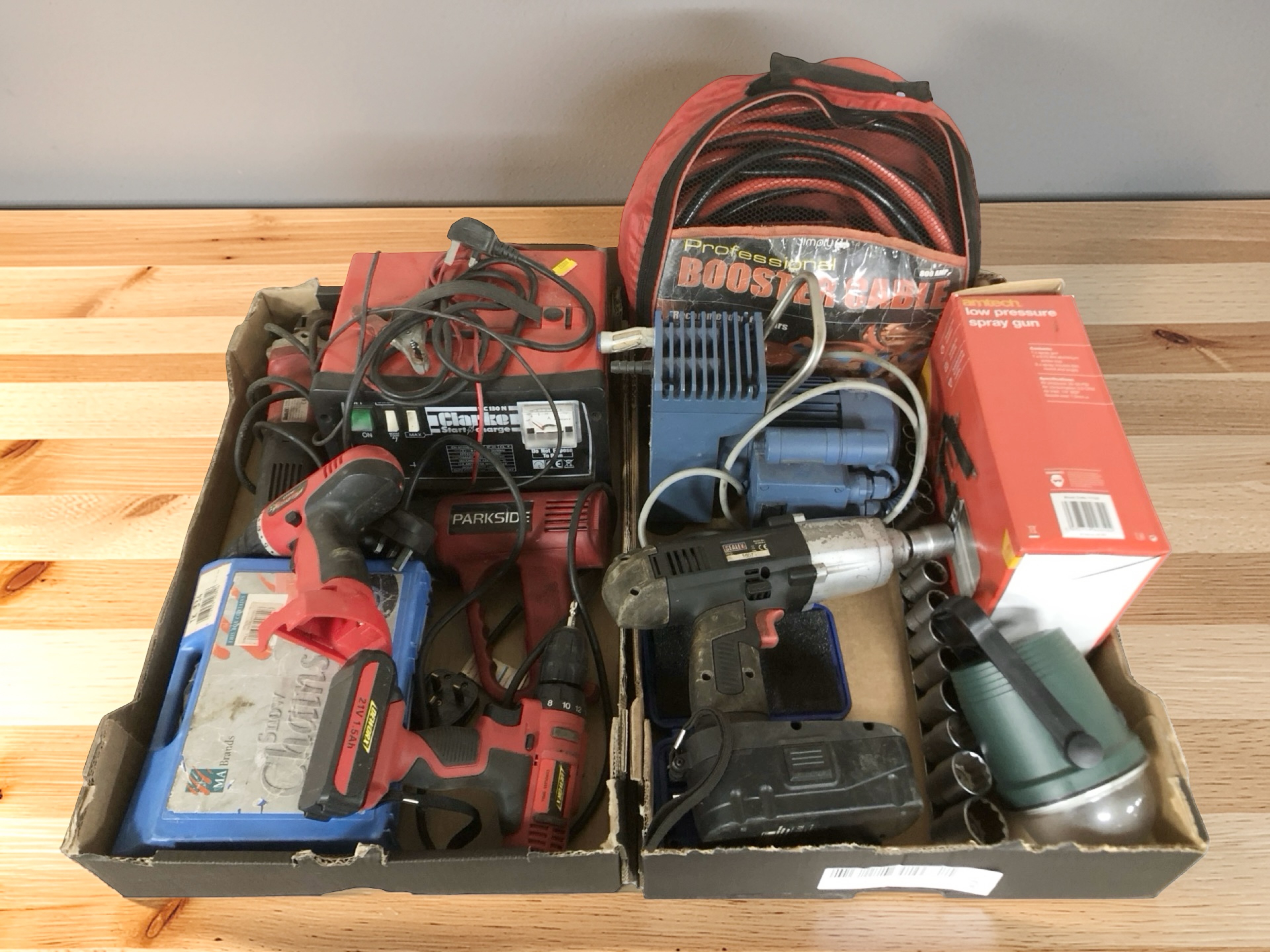Assorted power tools including drills, socket set, jump leads,