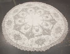 A fine early 20th century Italian linen circular tablecloth with embroidered foliate scrolls and