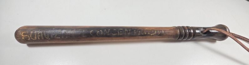 An unusual turned wooden truncheon with leather wrist loop, painted with Spanish inscription "