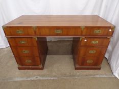 Campaign style desk having an arrangement of seven drawers with rebated brass handles, the lower two