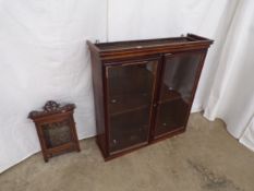 Mahogany display cabinet having two glass doors opening to single fixed shelf, standing on plinth
