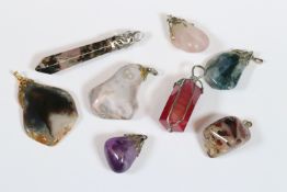 Eight polished gemstone pendants including amethyst, rose quartz, jasper, moss agate, rhodonite