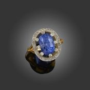 A SAPPHIRE AND DIAMOND CLUSTER RING, the cushion-shaped sapphire weighs 8.079cts, set within an