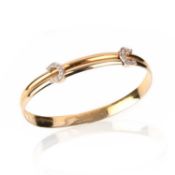 CARTIER, A FLEXIBLE GOLD AND DIAMOND 'C DE CARTIER' BANGLE, with two diamond-set Cs on expanding
