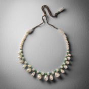 A NATURAL PEARL AND EMERALD NECKLACE, the graduated row of pearls alternately-set with carved