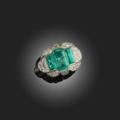 AN EMERALD AND DIAMOND BOMBÉ RING, set with a central step-cut emerald flanked with elongated