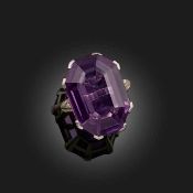 AN AMETHYST AND DIAMOND RING, EARLY 20TH CENTURY, the step-cut amethyst set within foliate shoulders